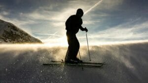 skiier on ski slope as sun setting